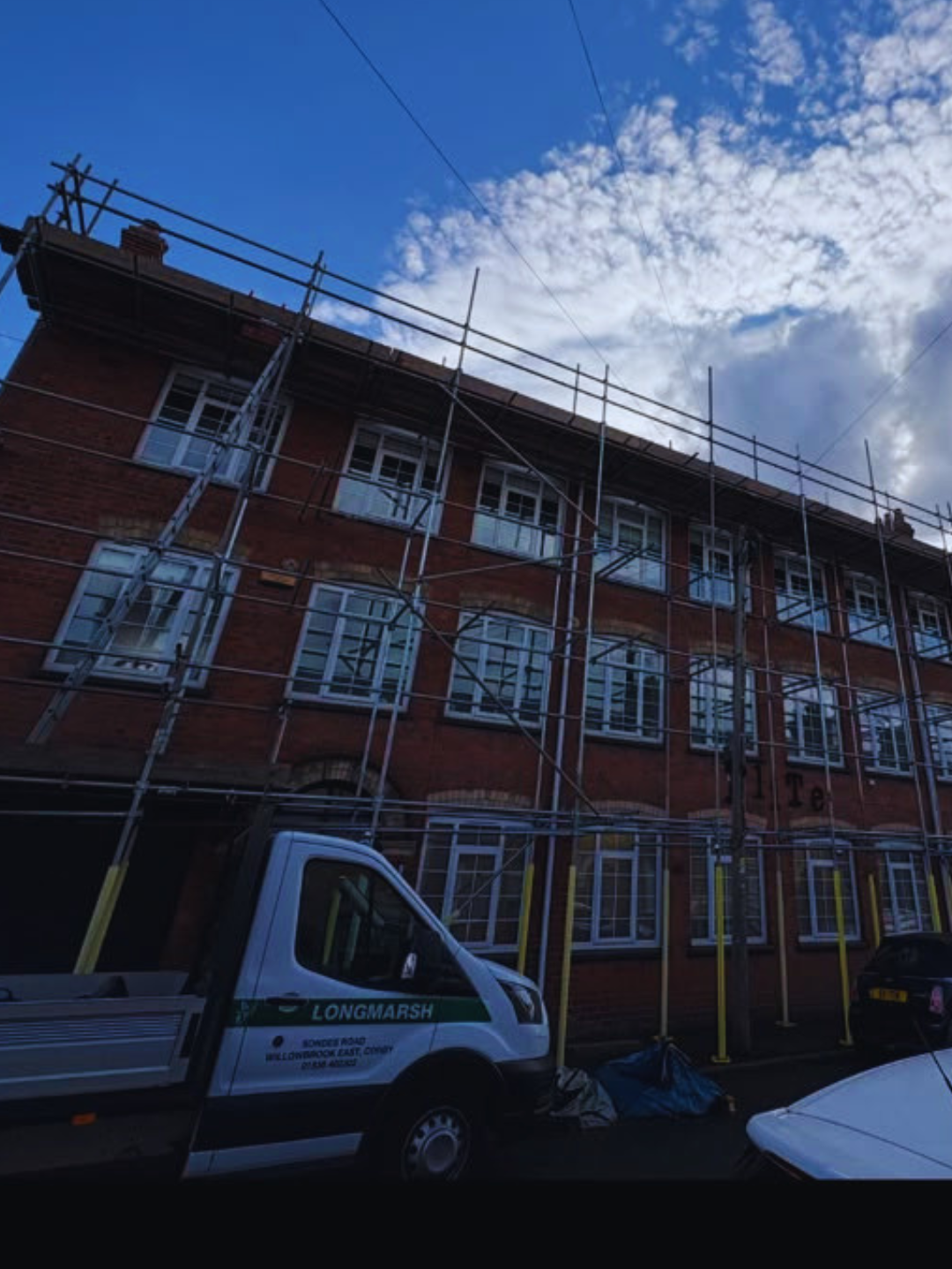 Pavement scaffolding to a three-storey brick building