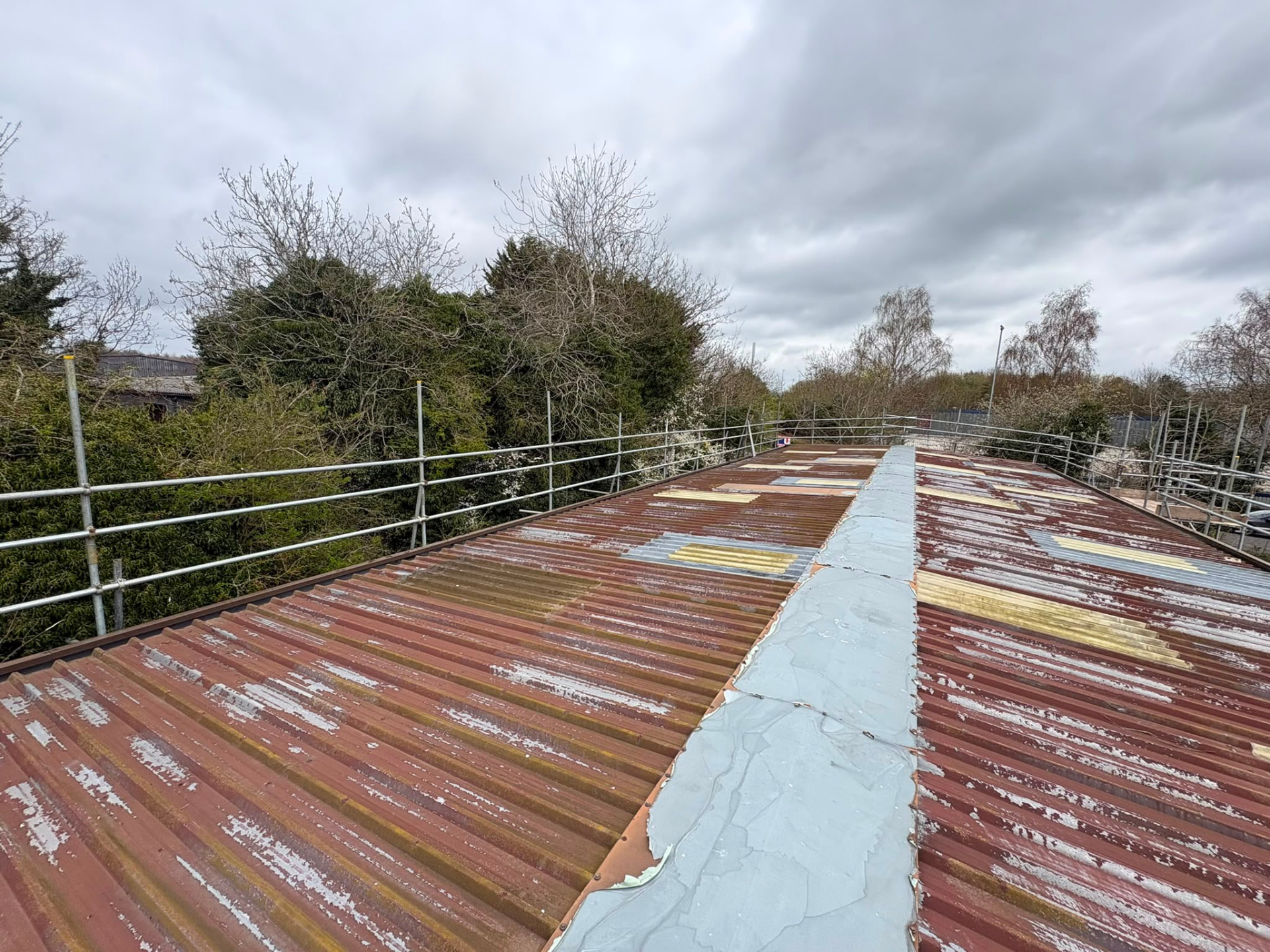 Perimeter edge protection scaffolding along a large corrugated industrial roof