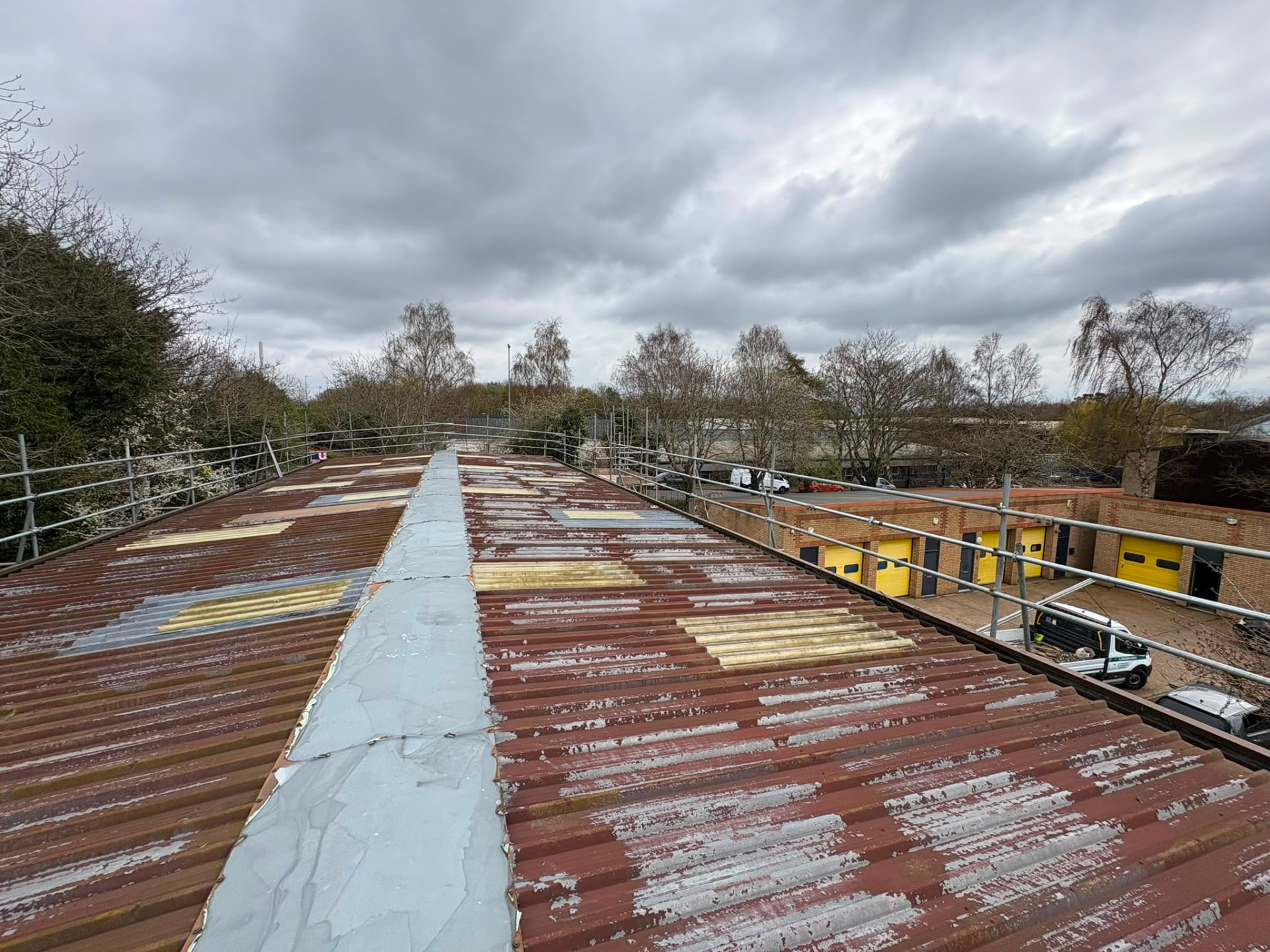 Edge protection scaffolding around a factory roof with safe walkway to the ridge